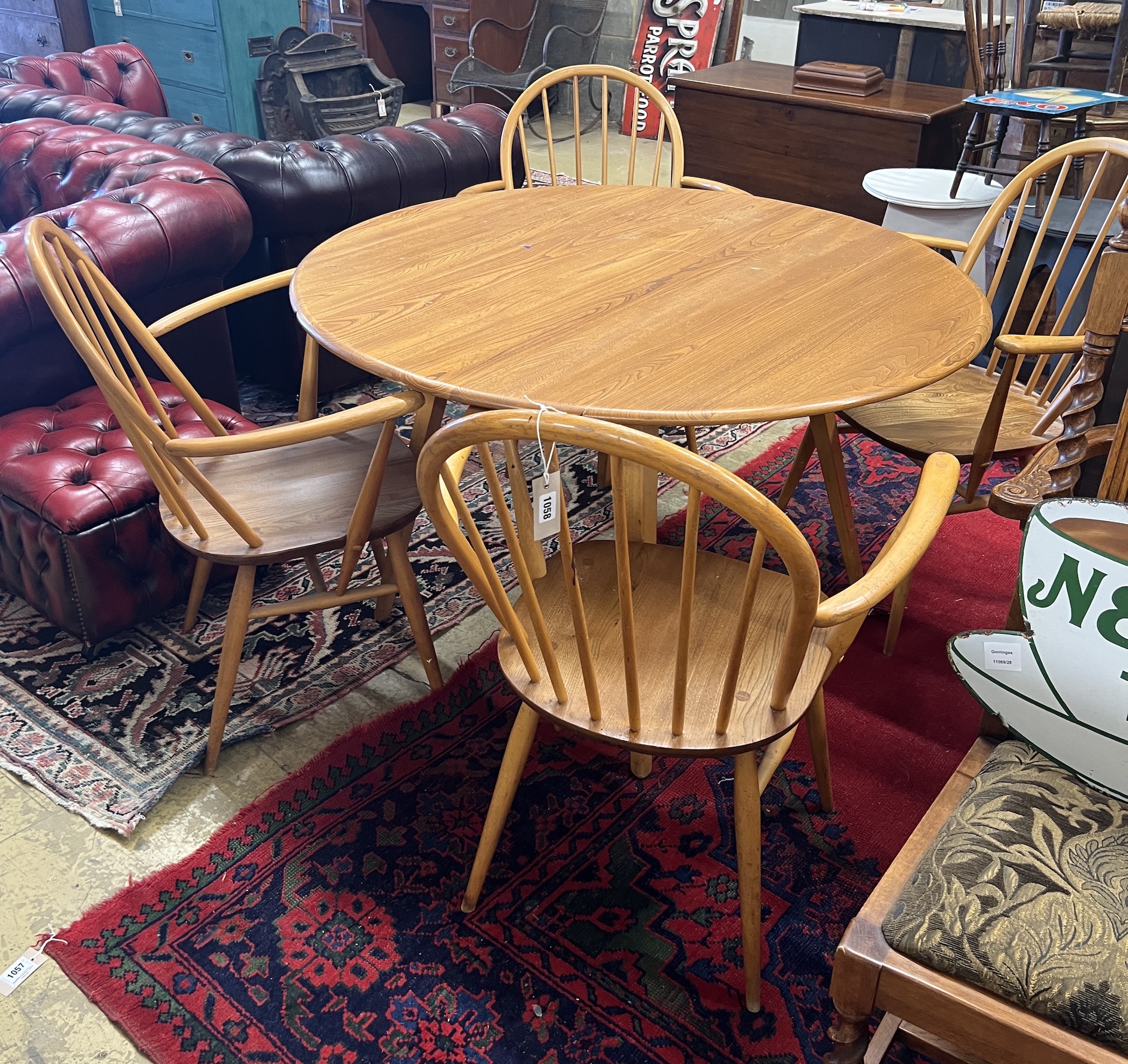 An Ercol oval elm drop leaf dining table, length 123cm extended, width 113cm, height 71cm and four Ercol elm and beech elbow chairs